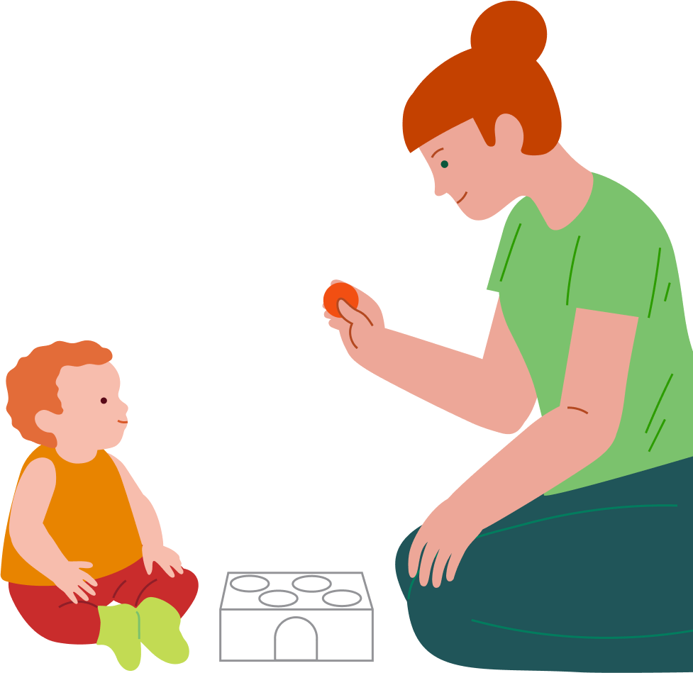 An adult holds out a ball to a toddler beside a shape-sorting box.