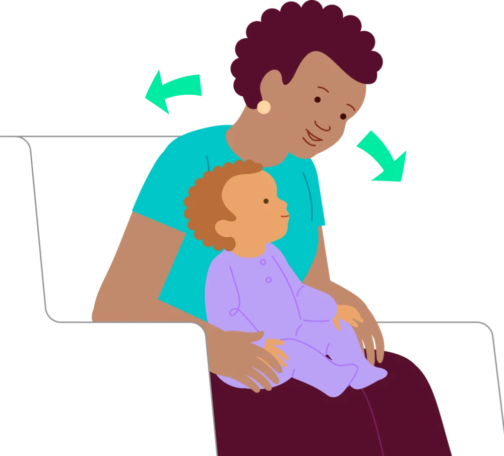A caregiver gently sways while holding the baby securely on their lap.